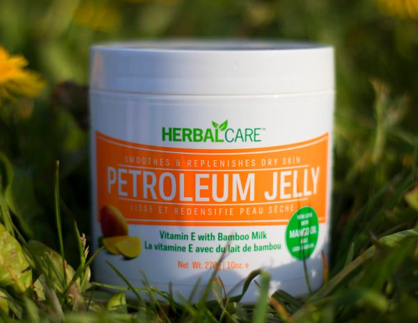 HERBAL CARE SMOOTHES & REPLENISHES DRY SKIN PETROLEUM JELLY MANGO OIL 10oz closeup in grass